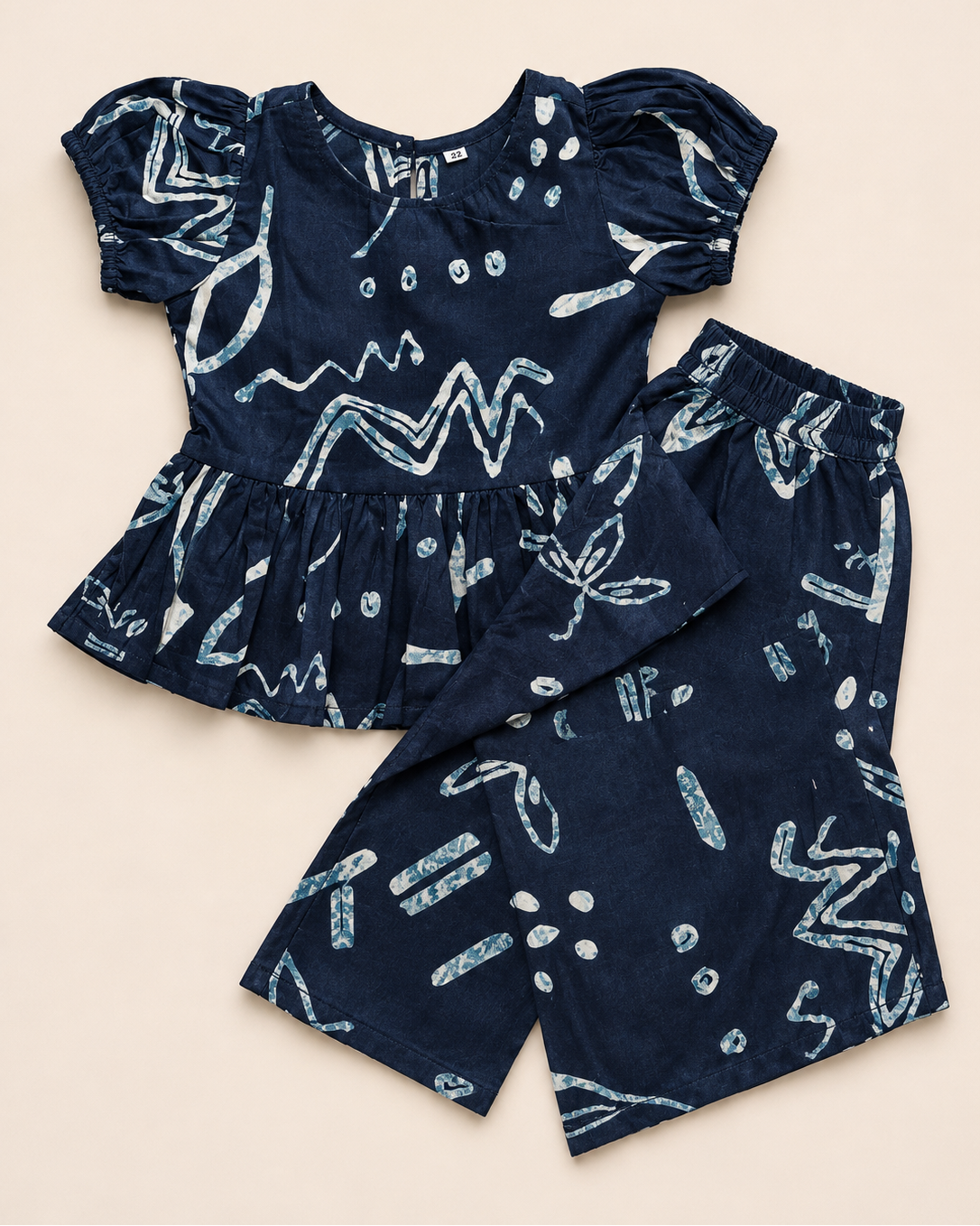 A navy blue outfit with white patterns, from Aruvo in beige color solid background