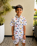 A toddler standing in balcony wearing Aruvo's premium cotton white co-ord set, with beautiful cars printed on it