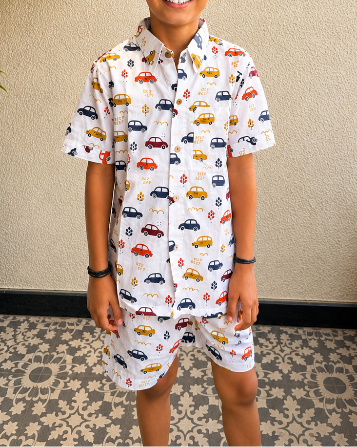 A toddler standing in balcony wearing Aruvo's premium cotton white co-ord set, with beautiful cars printed on it