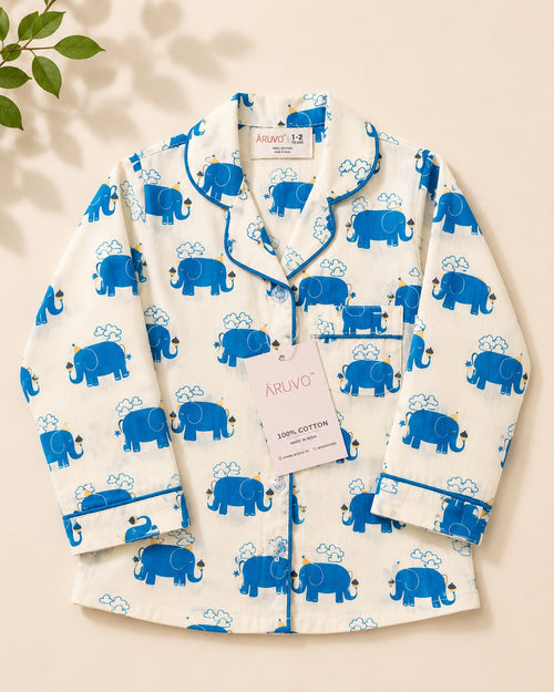 A long-sleeve pajama shirt laid flat on a light beige background, featuring a white base with a blue elephant print and blue piping, from brand Aruvo