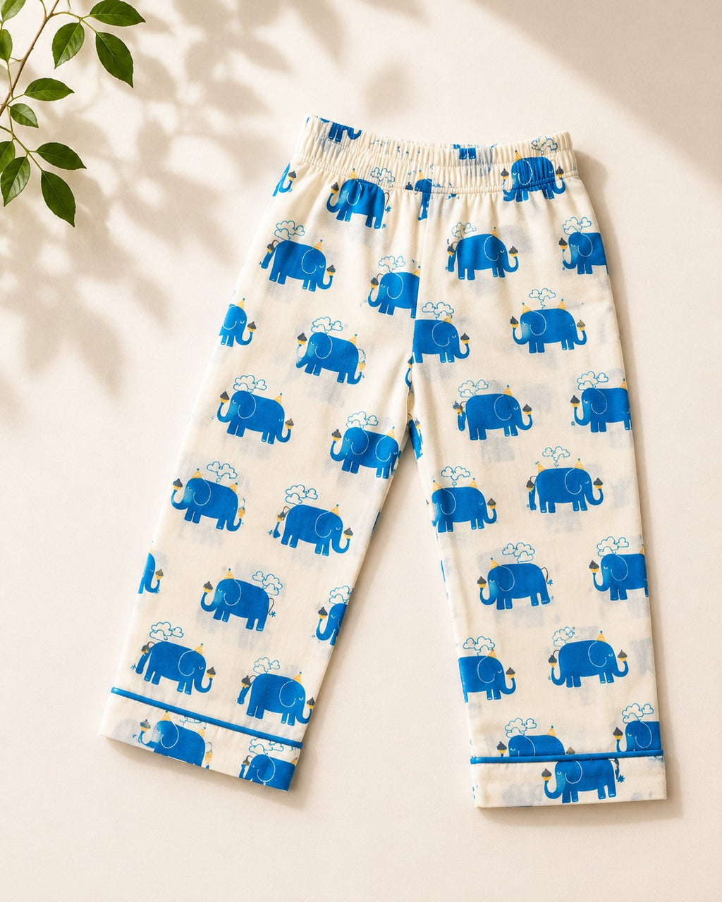 A pant with elephant printed on it is laid off on the beige background, from Aruvo