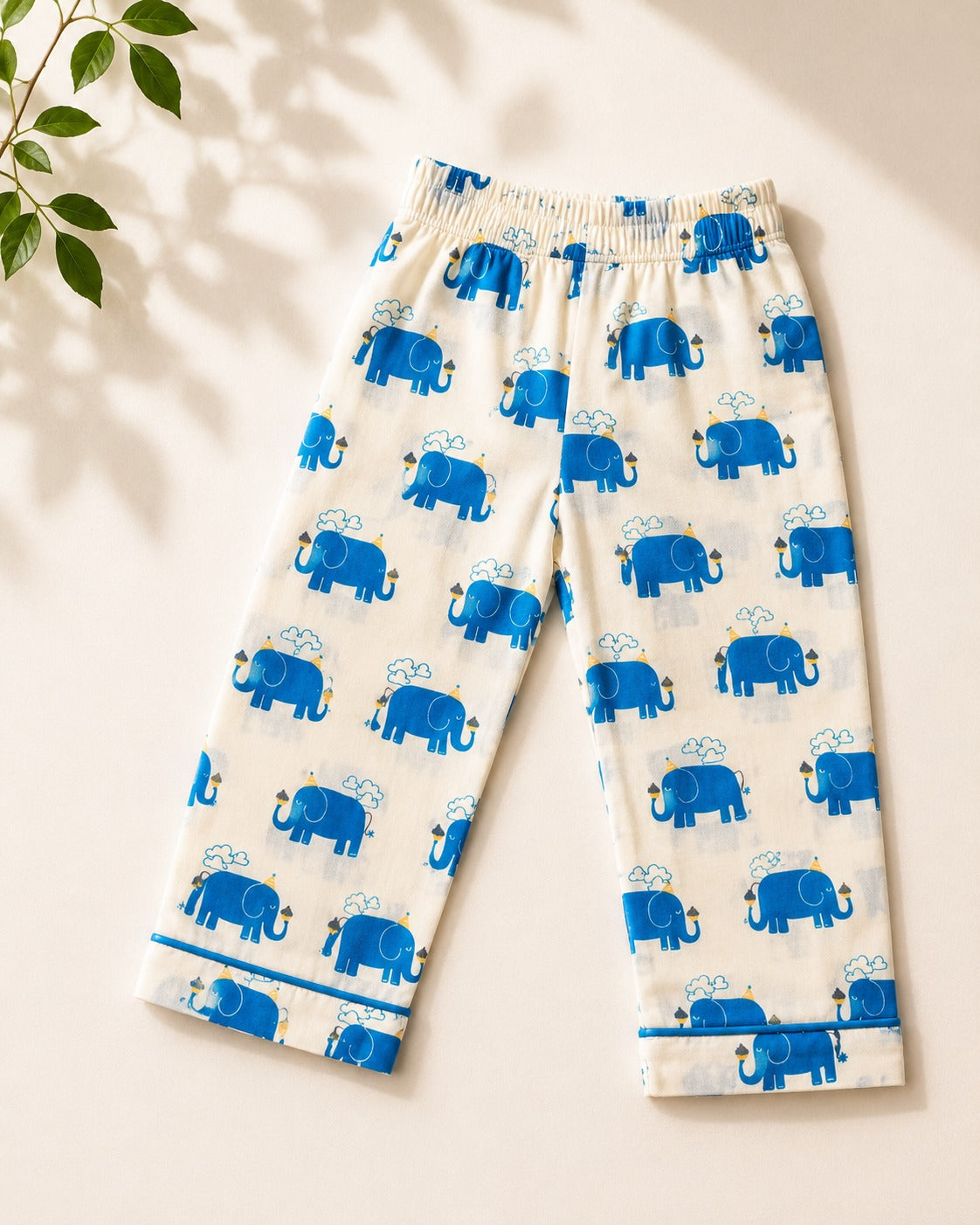 A pant with elephant printed on it is laid off on the beige background, from Aruvo