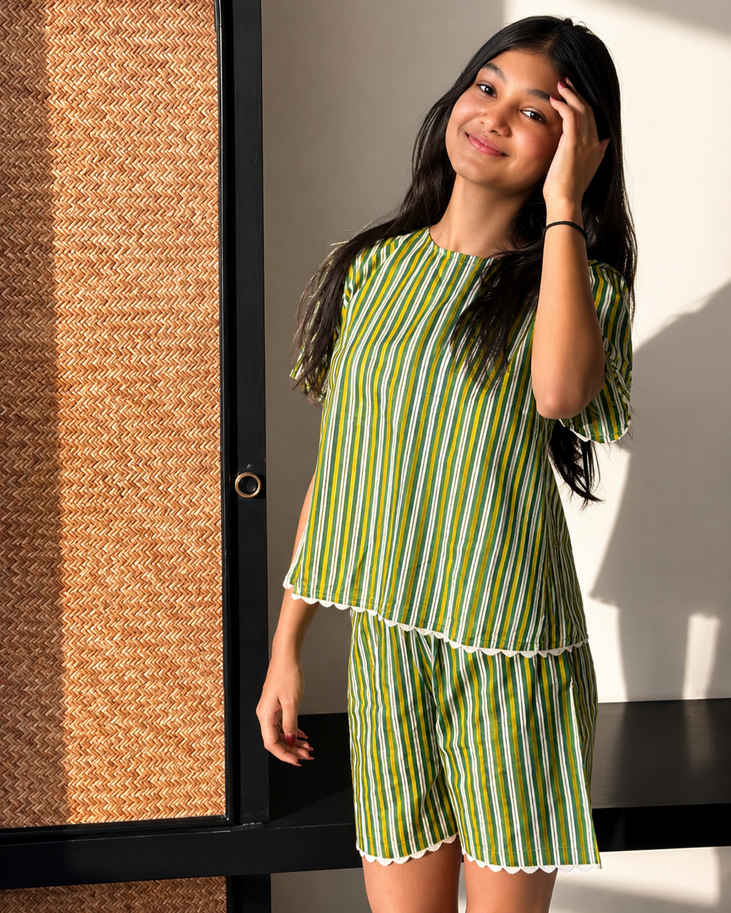 A girl wearing Aruvo's striped pure cotton stylish shorts set and standing near an open area 