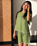 A girl wearing Aruvo's striped pure cotton stylish shorts set and standing near an open area 