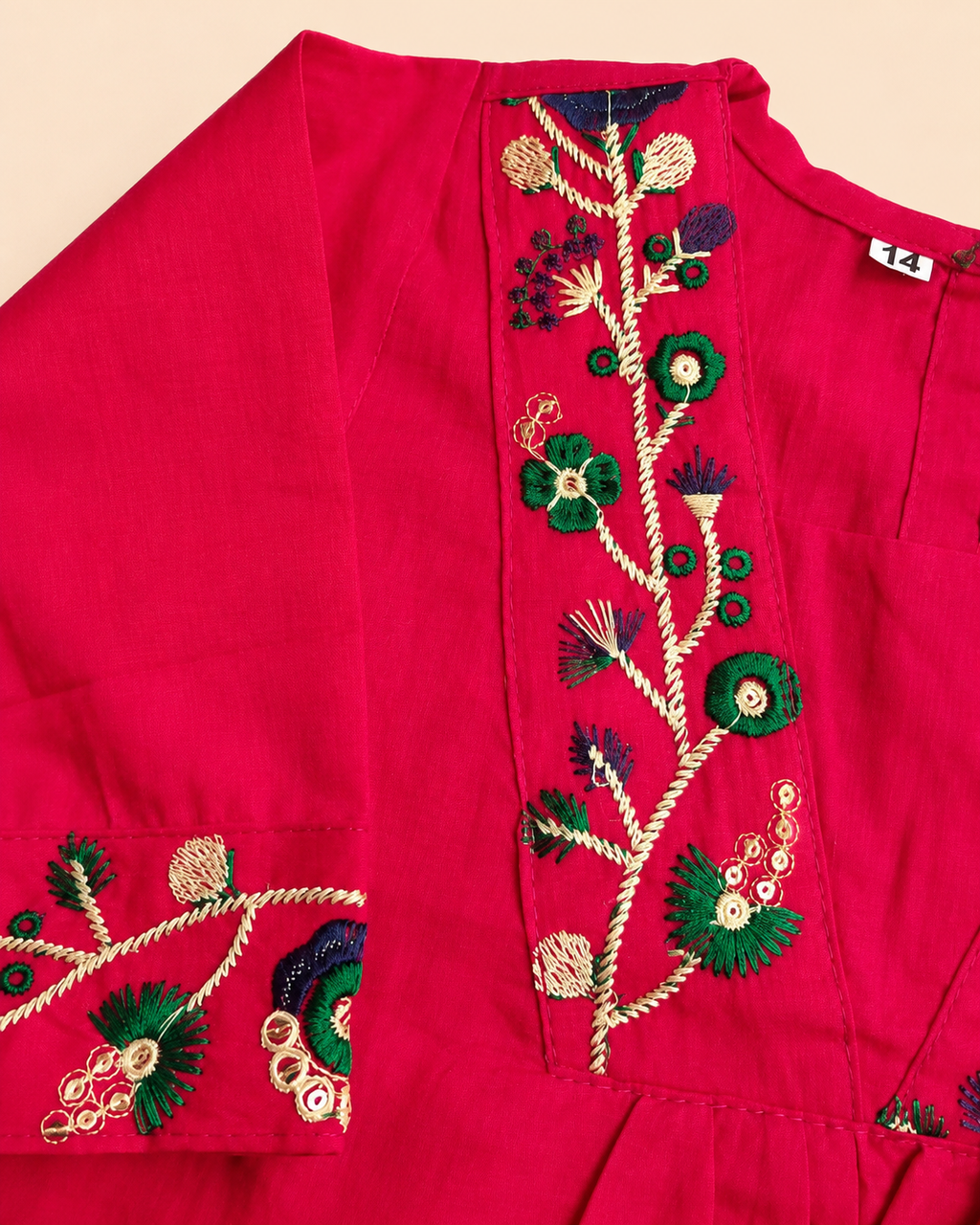 A close-up of a bright pink or magenta kurta featuring detailed floral embroidery on the front placket, from Aruvo