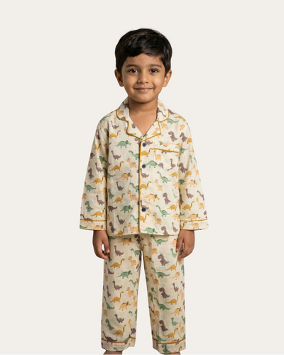 Child wearing a dinosaur-themed pajama set on a white background